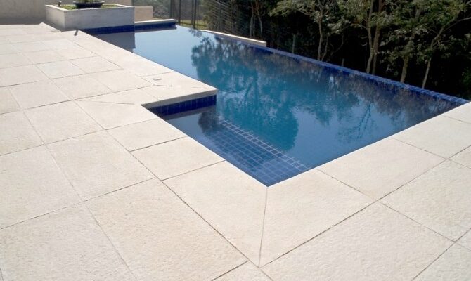 piso cimenticio Área externa com piscina e piso cimentício atérmico em tom bege claro.