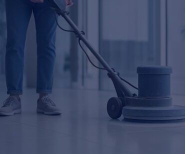 Profissional utilizando máquina de polimento para revitalização de piso porcelanato em ambiente corporativo, com acabamento técnico e filtro azulado.